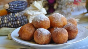 Bolinho de chuva dourado e polvilhado com açúcar e canela