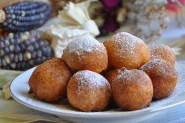 Bolinho de chuva dourado e polvilhado com açúcar e canela