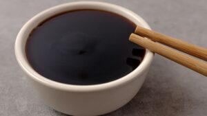 Molho teriyaki em uma tigela com gengibre ralado ao lado