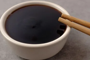 Molho teriyaki em uma tigela com gengibre ralado ao lado