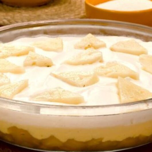 10 Receitas de Pavê Fáceis e Irresistíveis Para Qualquer Ocasião 1 Pavê de abacaxi decorado com coco ralado e pedaços de abacaxi