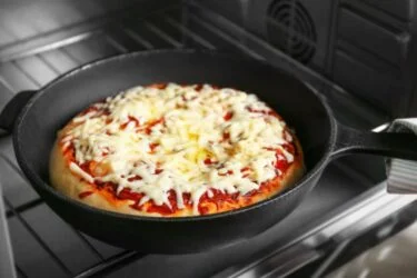 Pizza na frigideira com queijo derretido e rodelas de tomate