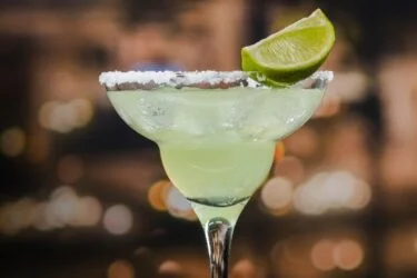 Taça de margarita com borda de sal e decorada com limão