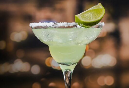 Taça de margarita com borda de sal e decorada com limão