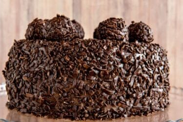 Brigadeirão de Chocolate cremoso decorado com granulado, servido em prato branco