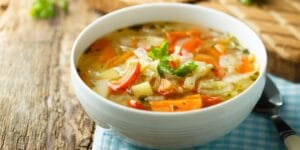 Sopa de legumes caseira servida em um prato fundo