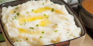 Purê de batatas cremoso, servido em prato branco