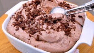 Sorvete de chocolate cremoso servido em taça com chocolate ao leite ralado por cima