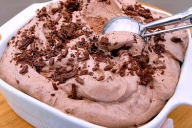 Sorvete de chocolate cremoso servido em taça com chocolate ao leite ralado por cima