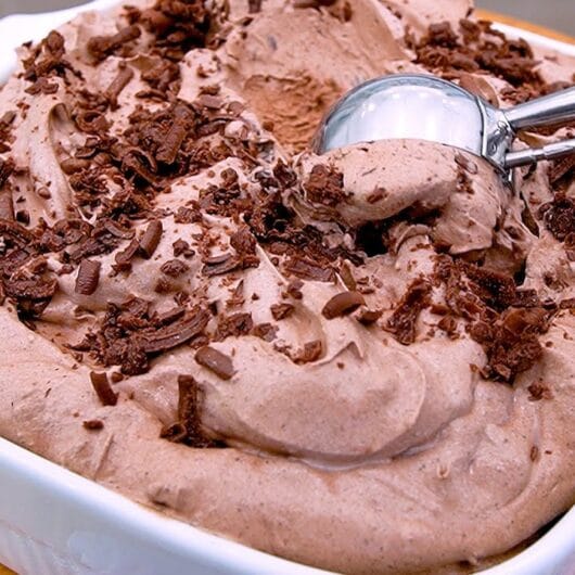 13 Receitas de Sorvete Fáceis e Cremosos Para Refrescar No Calor 7 Sorvete de chocolate cremoso servido em taça com chocolate ao leite ralado por cima
