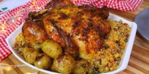 Frango assado recheado com farofa e batatas douradas.