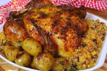 Frango assado recheado com farofa e batatas douradas.
