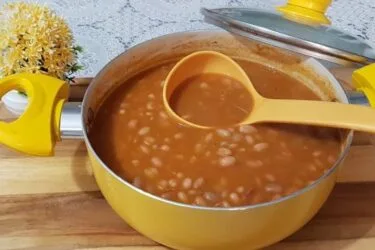 Feijão tradicional cozido servido com arroz e carne.
