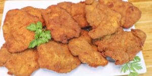 Frango à milanesa crocante e dourado servido em prato.