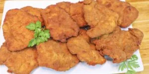 Frango à milanesa crocante e dourado servido em prato.