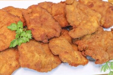 Frango à milanesa crocante e dourado servido em prato.