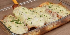 Frango à parmegiana servido com molho de tomate e queijo derretido.