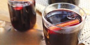 Quentão de vinho servido em copo com canela e especiarias.