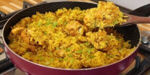 Arroz com frango cremoso e colorido servido em uma panela rústica