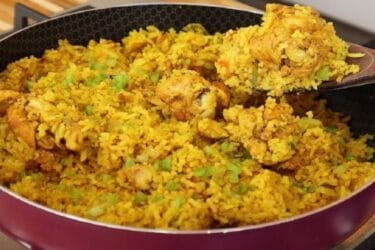Arroz com frango cremoso e colorido servido em uma panela rústica