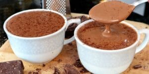 Caneca de chocolate quente cremoso com canela polvilhada por cima