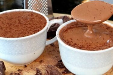 Caneca de chocolate quente cremoso com canela polvilhada por cima