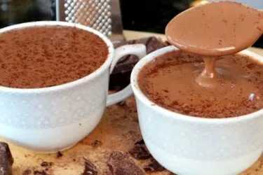 Caneca de chocolate quente cremoso com canela polvilhada por cima