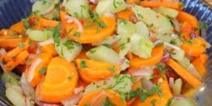 Salada de chuchu com cenoura, cebola e cheiro-verde servida em tigela branca