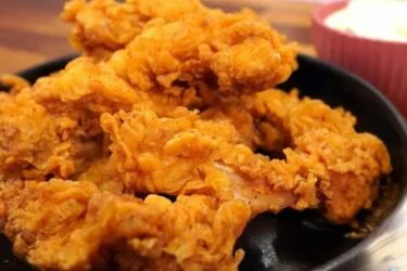 Frango frito crocante com casquinha dourada servido em prato