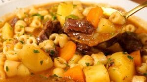 Sopa de músculo com legumes e macarrão servida em prato fundo