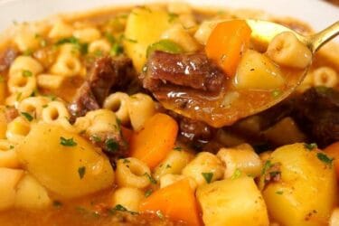 Sopa de músculo com legumes e macarrão servida em prato fundo