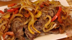 Bife acebolado com pimentão colorido e cebola dourada