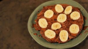 Panqueca de café fit com cobertura proteica e rodelas de banana