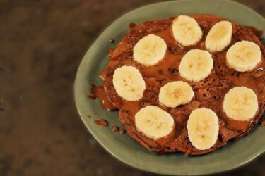 Panqueca de café fit com cobertura proteica e rodelas de banana