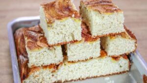 Bolo de banana de liquidificador fofinho com bananas fatiadas por cima