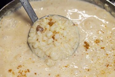 Canjica cremosa com paçoca servida em tigela