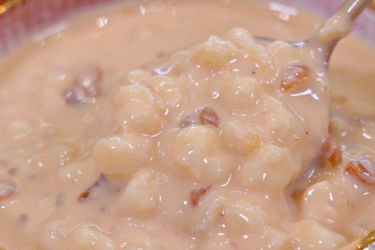 Canjica cremosa de doce de leite com amendoim servida em tigela