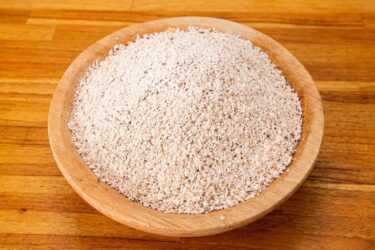 Farinha de coco caseira branquinha e soltinha dentro de um pote de vidro.