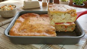 Pedaço de torta de palmito cremosa de liquidificador decorada com orégano, mostrando o recheio suculento por dentro.