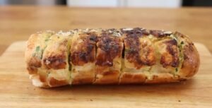 Pão de alho profissional especial para churrasco assado na grelha, douradinho, com queijo derretido e cheiro-verde por cima.