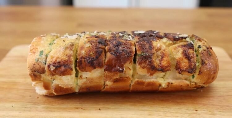 Pão de alho profissional especial para churrasco assado na grelha, douradinho, com queijo derretido e cheiro-verde por cima.