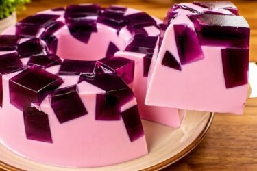 Pudim mousse de gelatina de 2 ingredientes desenformado em um prato, mostrando os cubinhos de gelatina envolvidos pelo creme mousse. Sobremesa de gelatina