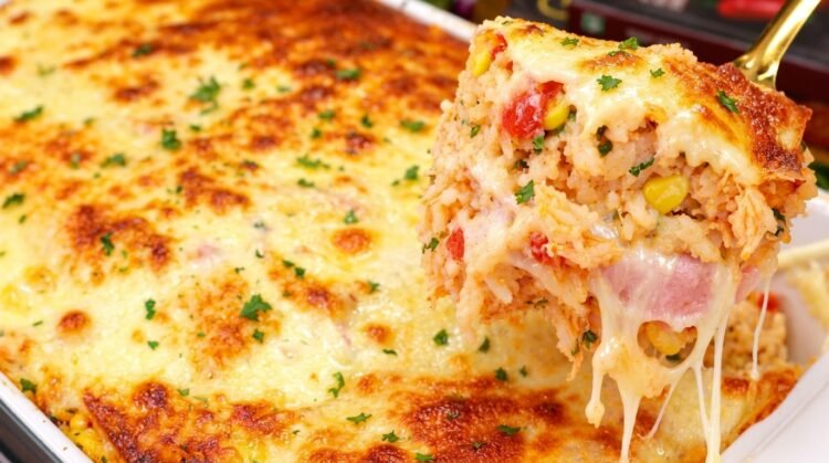 Travessa de vidro com arroz de forno completão recém-assado, mostrando o queijo muçarela gratinado e dourado por cima com orégano.