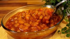 Travessa de vidro recheada com doce de banana caramelada em rodelas envolvidas em uma calda brilhante de caramelo.