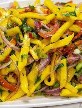 Salada com manga, pimentão e cebola roxa servida em tigela.