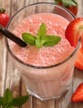 Batida de morango servida em taça com morangos frescos