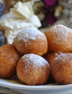 Bolinho de chuva dourado e polvilhado com açúcar e canela