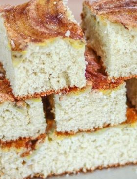 Bolo de banana de liquidificador fofinho com bananas fatiadas por cima