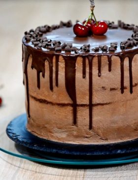 Bolo de chocolate com ganache escorrendo e cerejas
