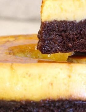 Bolo pudim com camadas de chocolate e pudim cremoso servido em fatia